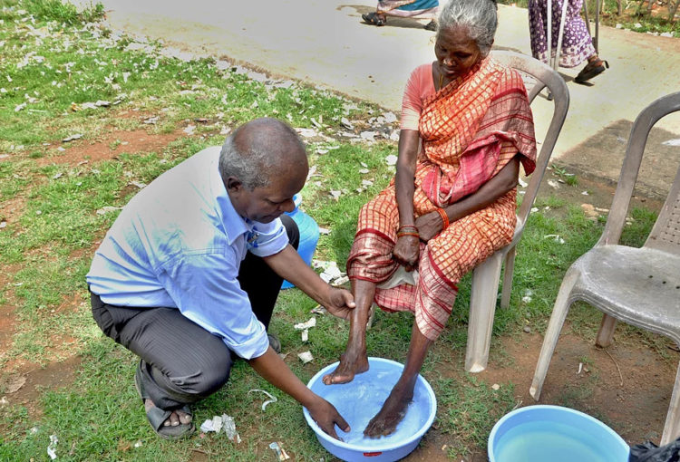 A CMCT social worker cares for an affected inhabitant of the leprosy colony.